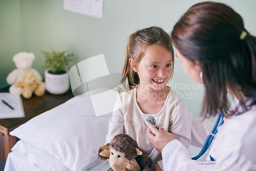 Image of Healthcare, kids and a girl at a woman pediatrician for an appointment or checkup in the hospital. Medical, stethoscope and cardiology with an adorable female child sitting on a bed in the clinic