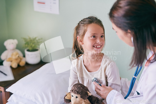 Image of Medical, children and a girl at the pediatrician for an appointment or checkup in the hospital. Healthcare, stethoscope and cardiology with an adorable female child sitting on a bed in the clinic