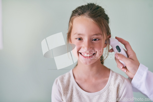 Image of Healthcare, children and a girl at the pediatrician for a temperature checkup or appointment in the hospital. Medical, ear and thermometer with an adorable female child sitting in a health clinic