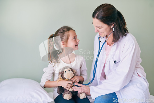 Image of Medical, kids and a girl at a woman pediatrician for an appointment or checkup in the hospital. Healthcare, stethoscope and teddy bear with an adorable female child sitting on a bed in the clinic