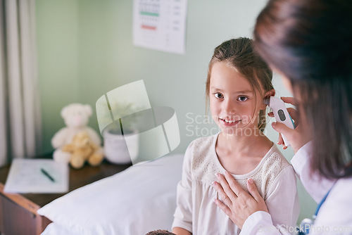 Image of Healthcare, portrait and a girl at the pediatrician for an ear checkup or appointment in the hospital. Medical, kids and health with an adorable little female child sitting on a bed in the clinic