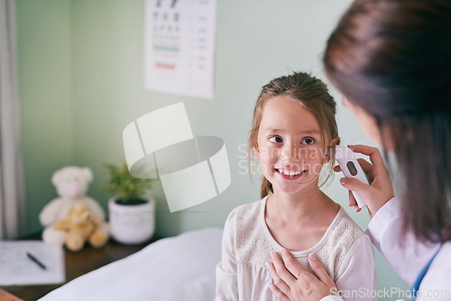 Image of Healthcare, kids and a girl at the pediatrician for an ear exam, appointment or checkup in the hospital. Medical, happy and temperature with an adorable female child sitting on a bed in the clinic