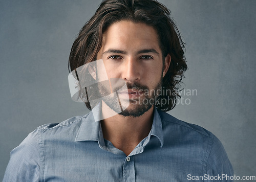 Image of Portrait, confident and business man with long hair, beard on gray studio background. Face, businessman and model with professional focus of entrepreneur, manager or casual corporate worker