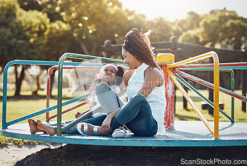 Image of Woman, young girl together on roundabout at park and playing with smile and fun outdoor. Love, care and bonding with family happiness, mother and daughter enjoying time at playground with freedom