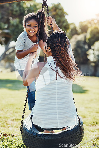 Image of Mother with daughter on swing at park, playing together with happiness and fun outdoor. Love, care and bonding with happy family in nature, woman and girl enjoying time at playground with freedom