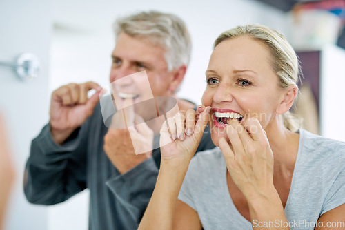 Image of Senior, couple and floss their teeth for fresh breath and a smile and healthcare at home. Elderly woman and man cleaning mouth for dental care in the bathroom for a healthy lifestyle and insurance.