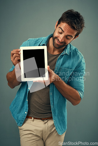 Image of Man, tablet and mockup screen for advertising, marketing or branding against a grey studio background. Happy male person with smile showing technology display or mock up space for advertisement