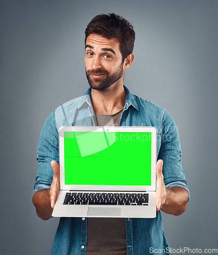 Image of Man, laptop and portrait with mockup green screen for advertising or marketing against a grey studio background. Male person showing computer display, chromakey or mock up space for advertisement