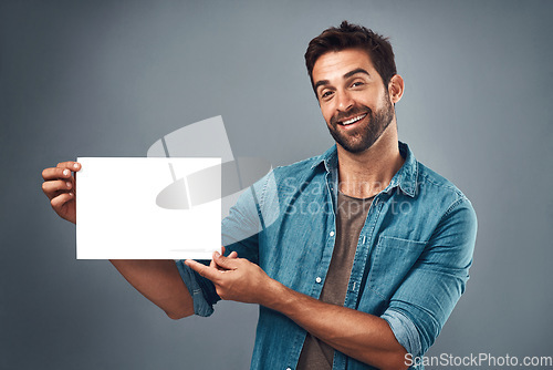 Image of Happy man, billboard and mockup for advertising, marketing or branding against a grey studio background. Portrait of male person holding rectangle poster, placard or board of empty sign for message