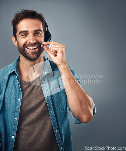 Image of Happy man, call center and headphones of consultant on mockup against a grey studio background. Portrait of friendly male consulting agent smiling with headset mic in contact us for online advice