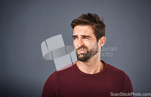 Image of Doubt, thinking and face of unsure man in studio with worry, uncertain and thoughtful on gray background. Confused, mockup space and isolated male person skeptical for decision, choice and question