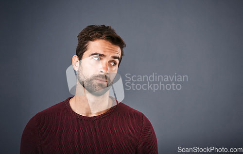 Image of Doubt, thinking and face of unsure man in studio with worry, uncertain and thoughtful on gray background. Confused, mockup space and isolated male person skeptical for decision, choice and question