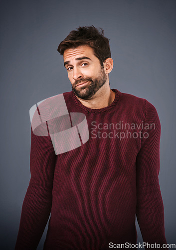 Image of Confused, shrug and portrait of man in studio unsure against a grey background space. Doubt, face and shrugging male with dont know expression, puzzled and pensive with person with question isolated