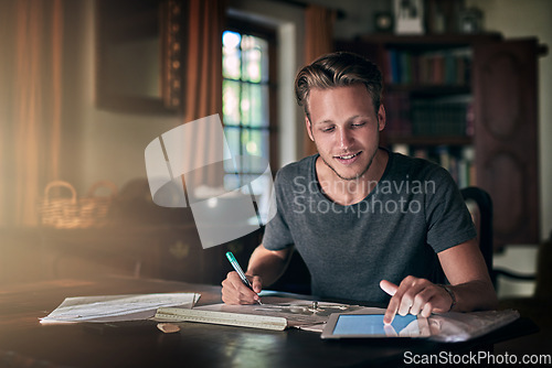 Image of College homework, studying and a man with a tablet for research, education and elearning. Smile, working and a male student with technology for information and planning for an exam in a house