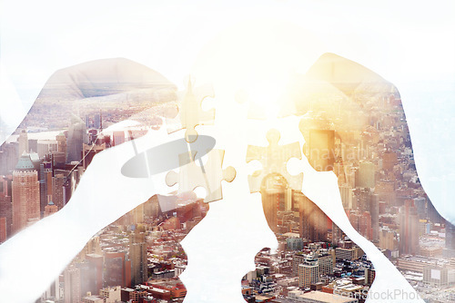 Image of Problem solving, city and hands of people with puzzle pieces in a studio for teamwork or partnership. Collaboration, solution and closeup of group of employees working together by a white background.