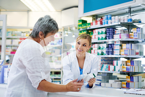 Image of Pharmacist explaining medicine to a woman in the pharmacy for pharmaceutical healthcare prescription. Medical, counter and female chemist talking to a patient about medication in a clinic dispensary