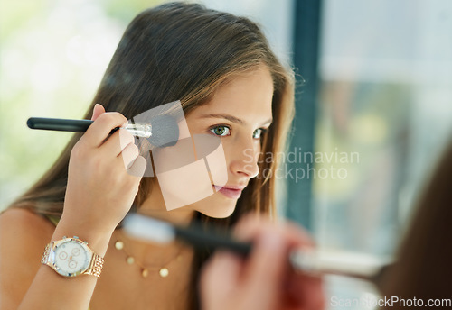 Image of Beauty, makeup and blush with a woman in the bathroom, using her reflection to apply cosmetics to her face. Mirror, brush and morning routine with an attractive young female person applying blusher