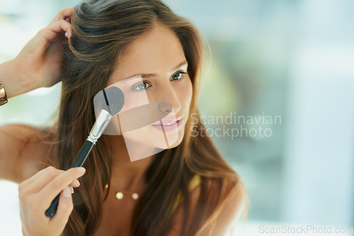 Image of Beauty, makeup and blusher with a woman in the bathroom, using a mirror to apply cosmetics to her face. Reflection, brush and morning routine with an attractive young female person applying blush