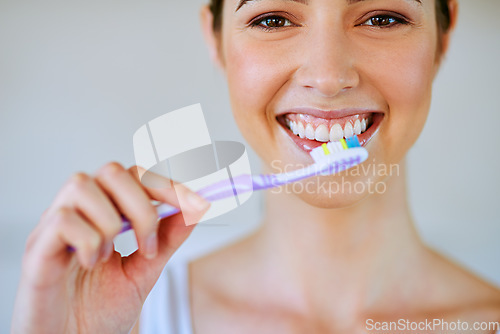 Image of Toothpaste, toothbrush and woman brushing teeth in bathroom for health, happiness and wellness in morning. Girl, portrait and cleaning mouth or healthcare, dental care or oral hygiene, smile or home