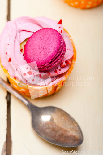 Image of pink berry cream cupcake with macaroon on top