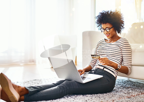 Image of Woman, laptop and credit card on living room house doing online shopping sitting on ground. Home, bokeh mockup and computer of African female person buying on a ecommerce app reading online deal