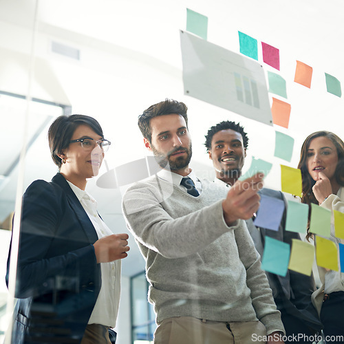 Image of Business people, teamwork and planning with sticky note, brainstorming or talk for solution, idea or goal. Group, glass board and focus with concentration for proposal, project or team in workplace