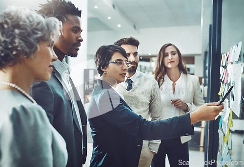 Image of Business people, teamwork or woman writing on board for brainstorming or speaking of solution, ideas or goals. Group planning, sticky note or group with leadership for project collaboration together