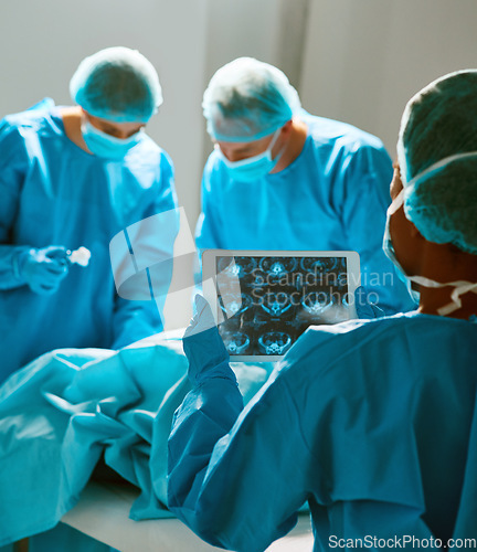 Image of Surgery, operating room and team of doctors with scan for healthcare, teamwork and focus on professional medicine. Medical innovation, technology and surgeon with xray, tablet and staff in hospital.