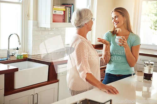 Image of Mother, coffee or happy woman chatting in kitchen in family home bonding or enjoying quality time together. Smile, retirement or daughter talking, relaxing or drinking tea with senior parent on break