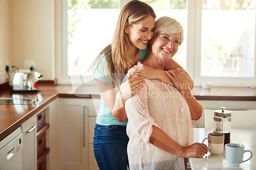 Image of Mother, coffee or happy woman hugging in kitchen in family home bonding to enjoy time together. Embrace, affection or funny daughter relaxing or drinking tea with senior parent or mom in retirement
