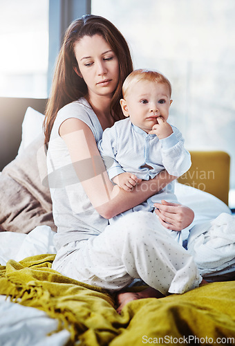 Image of Tired, wake up and a mother with her baby in the bedroom of their home in the morning as a single parent. Family, children and an exhausted young woman sitting on the bed with her infant son