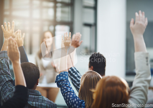 Image of Seminar, audience from back with hands up for questions and answers at training presentation or meeting. Feedback, opinion and ideas, group of people at conference, hand in air and talk at tradeshow.