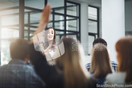 Image of Woman speaker at seminar, audience with hands up for questions and answers at training presentation or meeting. Feedback, opinion and ideas, group of people at conference, hand in air and question.