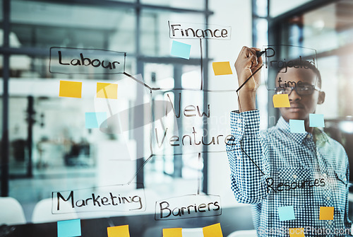 Image of Businessman, writing and schedule planning in brainstorming for strategy on glass board at office. Serious man employee planner busy on project plan of tasks, sticky note and mind map at workplace