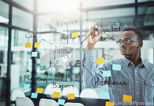 Image of Businessman, writing and brainstorming mind map for strategy, planning or ideas on glass board at office. Serious man employee in business schedule or project plan of sticky note tasks at workplace