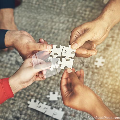 Image of Hands, team and puzzle for teamwork or collaboration of business people for challenge or project. Above group of employees or friends building jigsaw together for solution, synergy or problem solving