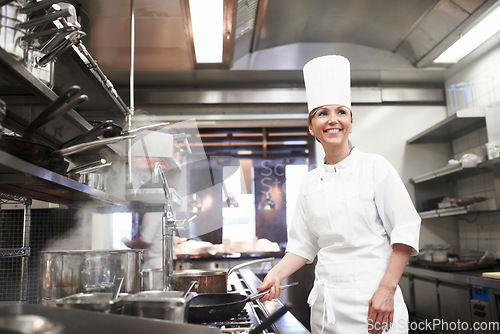 Image of Chef, woman and smile with frying pan in kitchen, catering service and prepare food for fine dining in restaurant. Professional, cooking and female person saute, cook and thinking about hospitality.