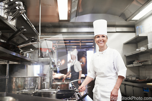 Image of Chef, woman and happy with frying pan in kitchen, catering service and prepare food for fine dining in restaurant. Professional, cooking and female person saute, cook and thinking about hospitality.