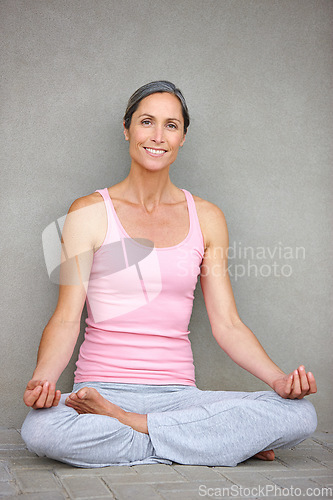 Image of Space, yoga and portrait of old woman in lotus pose on floor for meditation, healing and balance on wall background. Mindfulness, face and happy elderly lady meditating in retirement for wellness