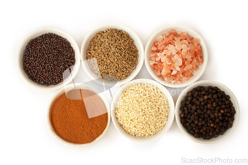 Image of Bowls, spices and full of cooking herbs or above view of powder for seasoning or taste in food and against a white. background. Nutrition, diet and dishes of garlic or natural coriander and in studio