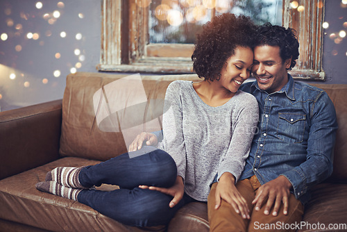 Image of Hug, love and happy couple relax on a sofa, romantic and bonding on date night with bokeh. Interracial relationship, romance and man embrace woman on a couch, smile and chilling in a living room