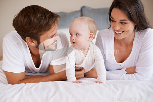 Image of Happy family, dad and mom with baby on bed for love, care and quality time together at home. Mother, father and cute newborn child relaxing in bedroom for happiness, support and development of kids