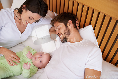 Image of Above of mother, father and baby in bedroom for love, care and quality time together at home. Happy parents, family and newborn kid relax on bed with support, childhood development and fun bonding