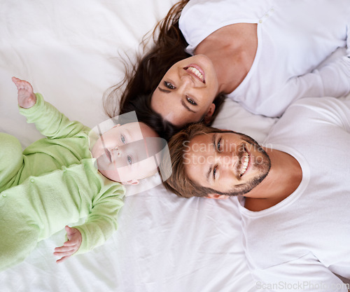 Image of Top view portrait of mother, father and baby on bed for love, care and quality time together at home. Happy parents, family and cute newborn kid relax in bedroom with smile, support and fun bonding