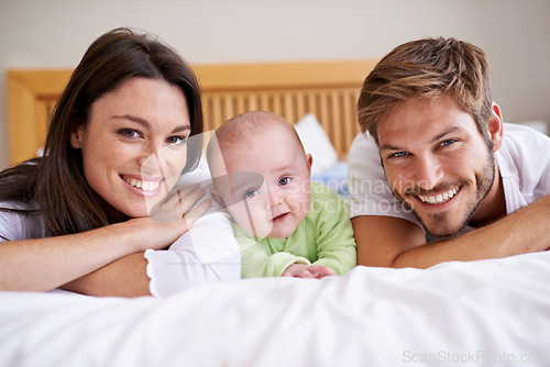 Image of Happy portrait of mother, father and baby on bed for love, care and fun quality time together at home. Parents, cute newborn child and family bonding to relax in bedroom for support, happiness or joy