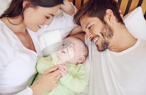 Image of Top view of happy family, parents and baby in bedroom for love, care and quality time together at home. Mother, father and newborn kid relax on bed with support, childhood development and happiness