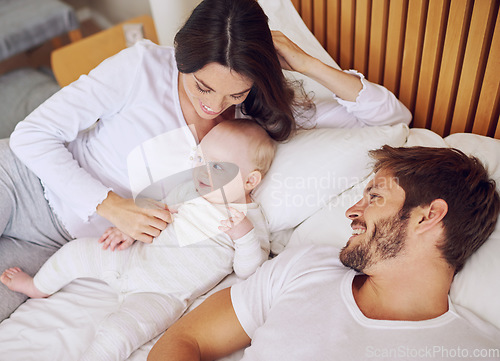 Image of Top view of mom, dad and baby on bed for love, care and quality time together at home. Happy parents, family and newborn kid relax in bedroom with support, childhood development and smile for bonding