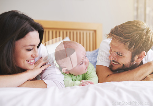 Image of Mother, father and baby relax on bed for love, care and fun quality time together at home. Happy family, parents and newborn bonding in bedroom for support, happiness or nurture childhood development