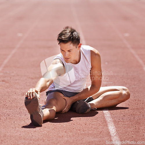 Image of Athlete, stretching and man outdoor for exercise, running or workout at sports stadium. Male runner or sport person on ground training legs and body for fitness, competition and wellness on track