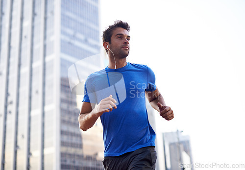 Image of Fitness, city and male athlete running for health, wellness or training for a marathon, competition or race. Sports, runner and man doing outdoor cardio exercise for endurance or speed in urban town.